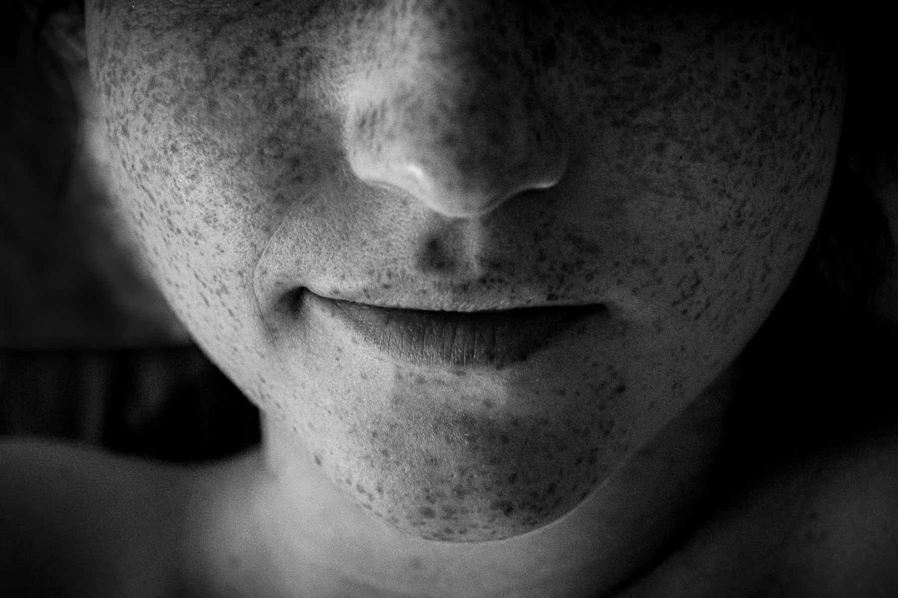 Black and white close view of freckles and a smile